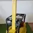 A Cargo PB60 5.5hp Vibrating Wacker Plate with black handles sits on artificial green grass indoors against a white wall—available now for tool hire in Newry.