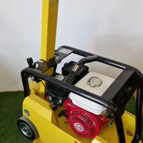 Cargo PB60 5.5hp Vibrating Whacker Plate-5 The Cargo PB60 5.5hp Vibrating Wacker Plate features a yellow body, red engine, and black handles, with a control panel. Available for tool hire Newry; pictured on artificial grass by a white wall.