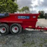 A red Tuff Mac DT14 Dump Trailer labelled "KILLEN Tools & Hire" and advertising tool hire Newry is parked on gravel near trees and a metal gate under a cloudy sky.
