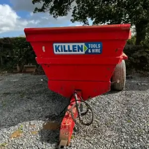 Tuff Mac DT14 Dump Trailer-2 A Tuff Mac DT14 Dump Trailer with a "KILLEN TOOLS & HIRE" sign, offering tool hire Newry services, is parked on gravel, surrounded by trees and bushes in the background.
