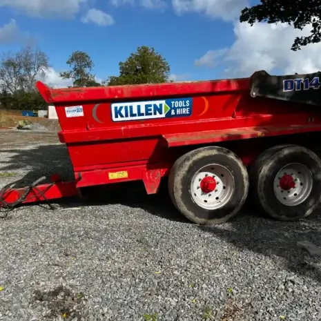 Tuff Mac DT14 Dump Trailer-3 A red Tuff Mac DT14 Dump Trailer with “KILLEN Tools & Hire” branding, a trusted tool hire name in Newry, is parked on gravel outdoors under a partly cloudy sky.