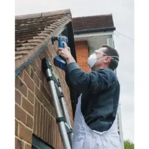 Draper Storm Forceยฎ 20V Oscillating Multi-Tool (Sold Bare)-2 A man uses the Draper Storm Forceยฎ 20V Oscillating Multi-Tool (Sold Bare) from tool hire Newry to complete his project efficiently.