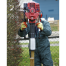 Wearing gloves and overalls, a person uses the Sealey 2-Stroke Petrol Post Driver 100mm from tool hire Newry to drive a wooden stake into the ground beside a fence and bush.